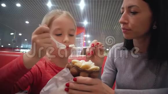 年轻的母女在咖啡馆里吃冰淇淋良好的亲子关系一起度过快乐时光家庭视频的预览图