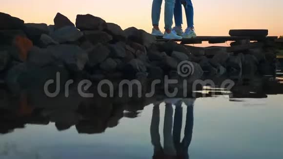 真实拍摄的情侣站在天空背景上的石头上抱着对方真爱的氛围令人惊叹的景色视频的预览图