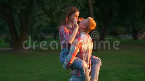 伟大的爱情镜头男孩正在亲吻他的女朋友用手牵着她转圈绿色移动视频的预览图