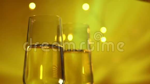 在金色的背景下将起泡香槟倒入玻璃杯中视频的预览图
