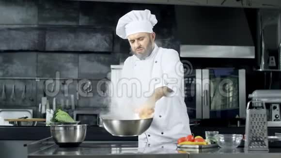 专业厨师在厨房里用燃烧的火焰把食物扔进锅里视频的预览图