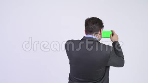 年轻的西班牙商人用电话拍照的后景视频的预览图