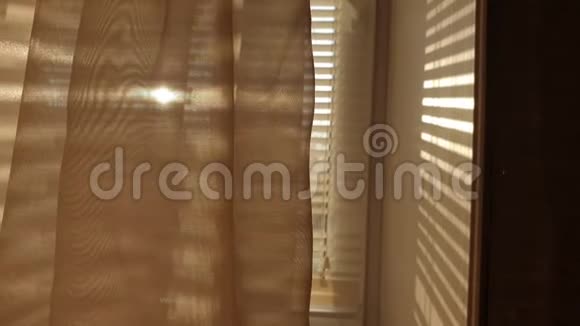夕阳透过百叶窗和薄薄的薄纱舒适和温暖的房子视频的预览图