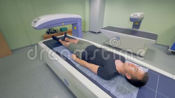 一个成年男子正被一台医疗机器扫描X光检查视频的预览图
