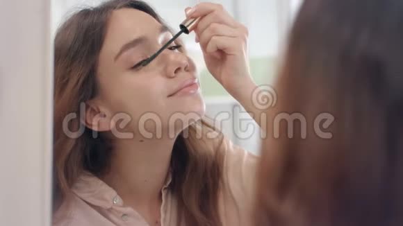 漂亮的女人用睫毛膏做睫毛前浴室镜子视频的预览图