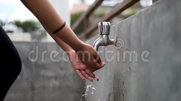 女孩在室外用自来水洗手视频的预览图