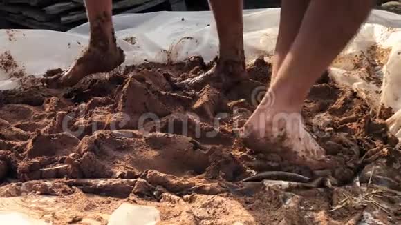 近距离拍摄赤足粘土揉捏建筑土坯简易房屋视频的预览图
