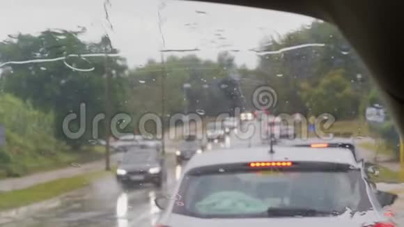 前面的屏幕和雨滴在交通堵塞的汽车上运输视频的预览图