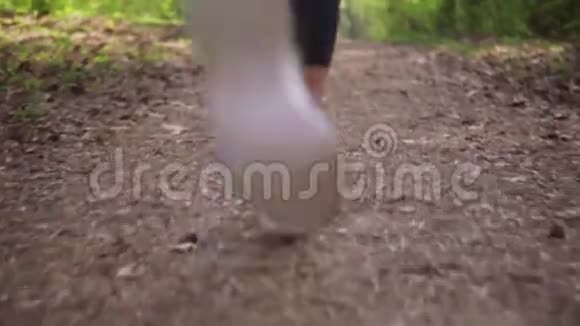 跑步者他的脚穿着运动鞋在森林里奔跑视频的预览图