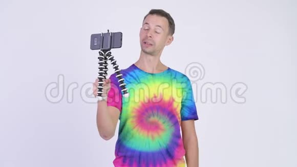摄影棚拍摄的男人穿着扎染衬衫用电话打广告视频的预览图