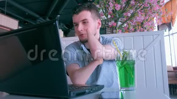 在咖啡馆里被截肢的残肢手的残疾人在笔记本电脑上视频聊天视频的预览图
