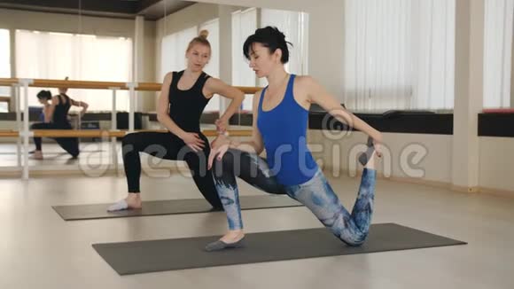健身中心两个女人在健身房做运动普拉提运动视频的预览图