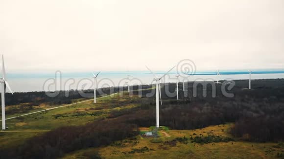 风景空中全景风车涡轮农场在秋林湖附近工作生态友好的环境理念视频的预览图