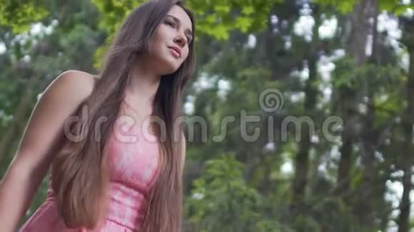 美丽的年轻女士穿着红色连衣裙走在户外黑发的女性在森林里视频的预览图