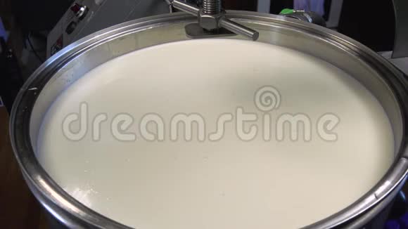 新鲜山羊牛奶在农场巴氏杀菌过程中混合在不锈钢罐中视频的预览图