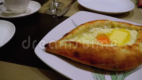 一家格鲁吉亚餐馆桌子上的阿贾里安卡查普里带蛋黄的开放式面包派视频的预览图