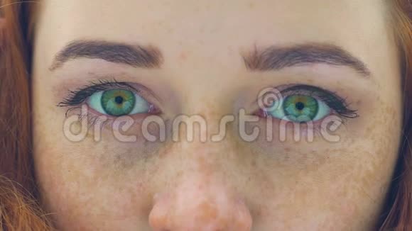 红发女人的雀斑脸上带着绿色的眼睛极度的近距离眨眼缓慢视频的预览图