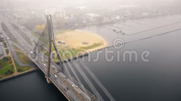 令人惊叹的空中城市景观交通电缆桥上的多加瓦在里加老城浓雾下的秋天天视频的预览图