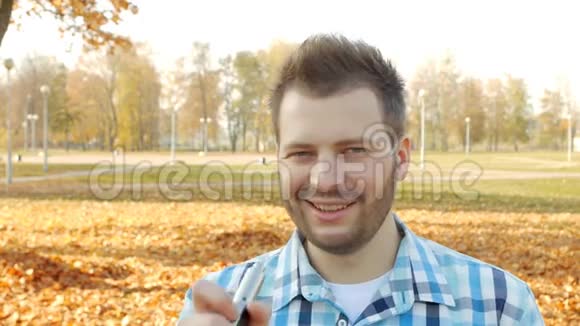 时尚时尚的男人留着胡子微笑着看着相机特写慢节奏生活方式视频的预览图