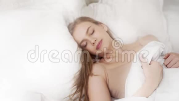 女人在阳光明媚的卧室里醒来清晨在温暖舒适的床上醒来一天开始女人视频的预览图