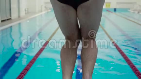 专业运动的男性游泳运动员从室内游泳池的起点跳入游泳池关门视频的预览图