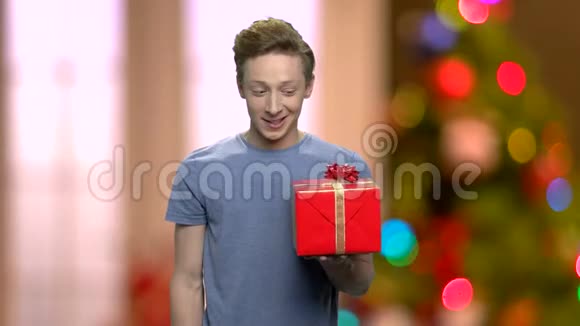 英俊害羞的男孩给你圣诞礼物盒视频的预览图