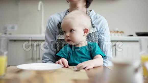 妈妈带着一个孩子坐在餐桌旁看着周围视频的预览图