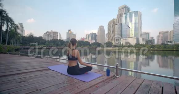 在繁忙城市的健身地毯上为健身女性提供户外放松的后景视频的预览图