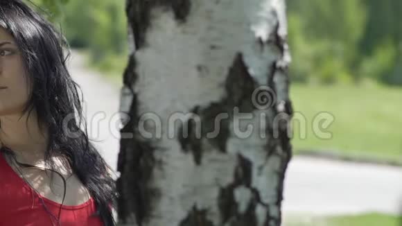 伤心的女人在分手后独自一人在公园的树下慢慢地看着视频的预览图