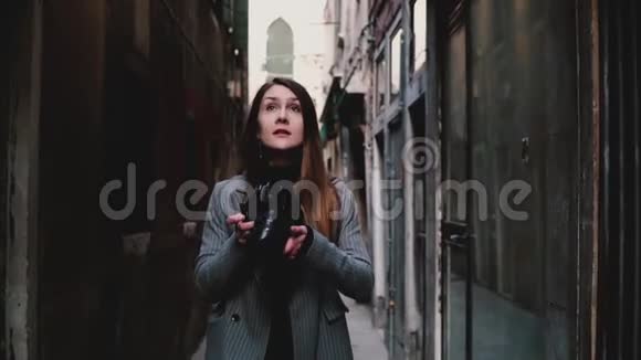 迷人的快乐职业记者女人与相机走在古威尼斯街拍照慢动作视频的预览图