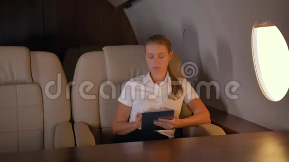 私人飞机里面有平板电脑的女商人视频的预览图