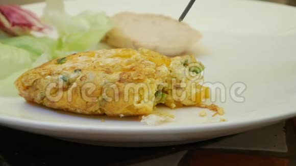 有人在餐馆里用叉子吃煎蛋卷用蔬菜煎鸡蛋好吃特写视频的预览图