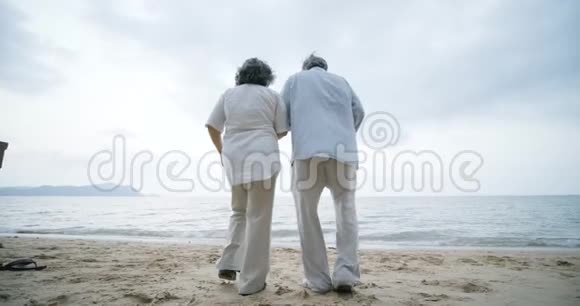可爱的亚洲老年夫妇奔向海洋视频的预览图