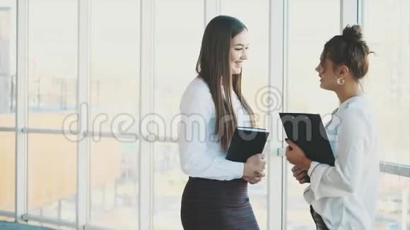 两个商务女孩微笑着聊天以成功地经商视频的预览图