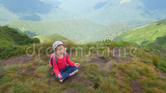 一个孩子在山顶上的莲花位置冥想视频的预览图