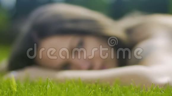 美丽的女性有纹身躺在草地上神情轻松看着无忧无虑的缓慢视频的预览图