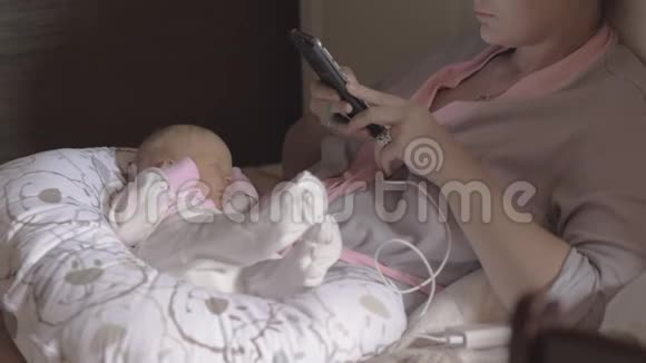 匿名妇女与婴儿使用智能手机视频的预览图