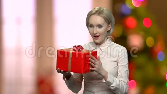 带着红色礼品盒的令人惊讶的办公室女人视频的预览图