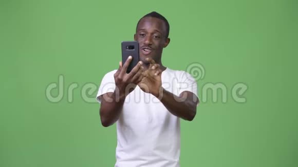 非洲青年男子绿色背景下打电话的视频视频的预览图
