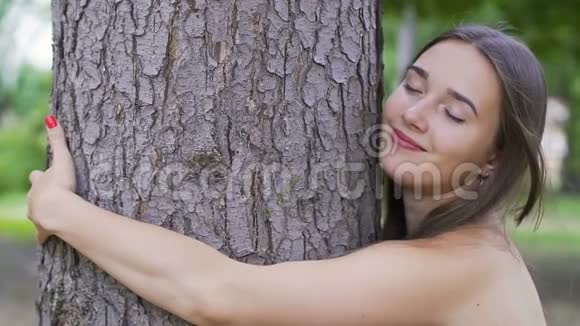 美丽的女人拥抱一棵树感受与自然的统一对生活的热爱户外的团结视频的预览图