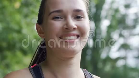 美丽的微笑面对奔跑的女人微笑的美丽女士在公园慢跑视频的预览图
