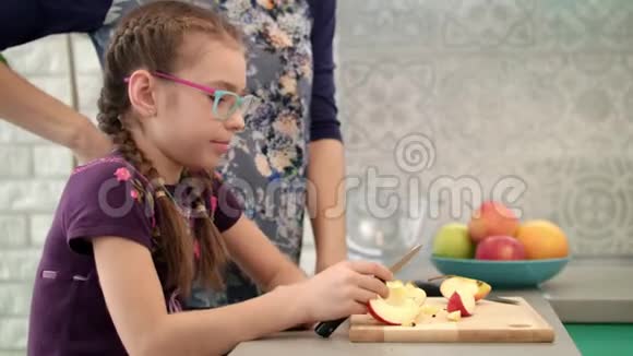 女孩在厨房吃苹果片孩子和妈妈一起在厨房吃水果视频的预览图