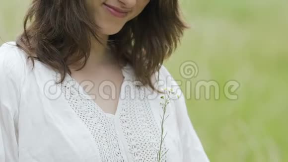 年轻的亚美尼亚女子画像花在田野上露出友好的微笑视频的预览图