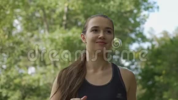 可爱的年轻女子在公园跑步新鲜空气慢跑运动生活方式女士视频的预览图