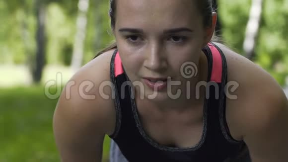 疲惫的女运动员在户外跑步后呼吸沉重疲惫的女运动员缓慢视频的预览图