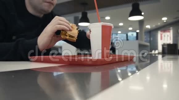 盖伊在餐馆吃汉堡或吉肯汉堡喝甜碳酸水视频的预览图