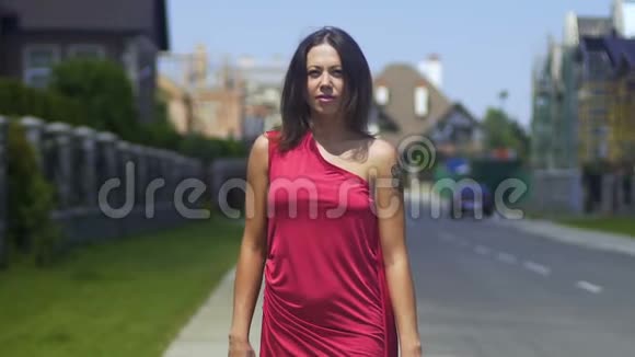 穿着红色衣服的女士在大街上走得更近了漂亮的女士朝视频的预览图