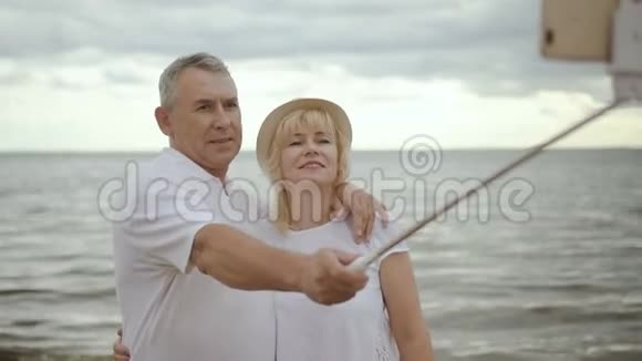 快乐的成熟夫妇在镜头上接吻在海边自拍视频的预览图