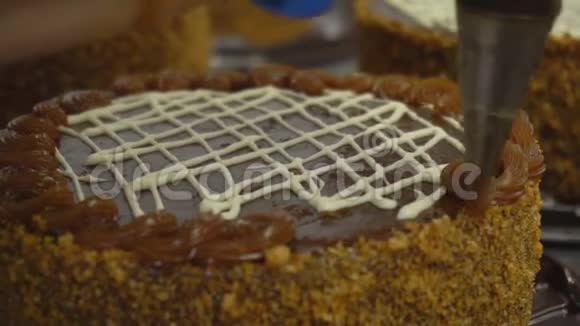 一家糖果厂的糕点厨师做新鲜美味的蛋糕奶油蛋糕装饰食品工业视频的预览图