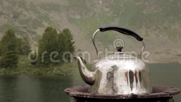 铁壶正在一座山湖的岸边沸腾野营钳视频的预览图